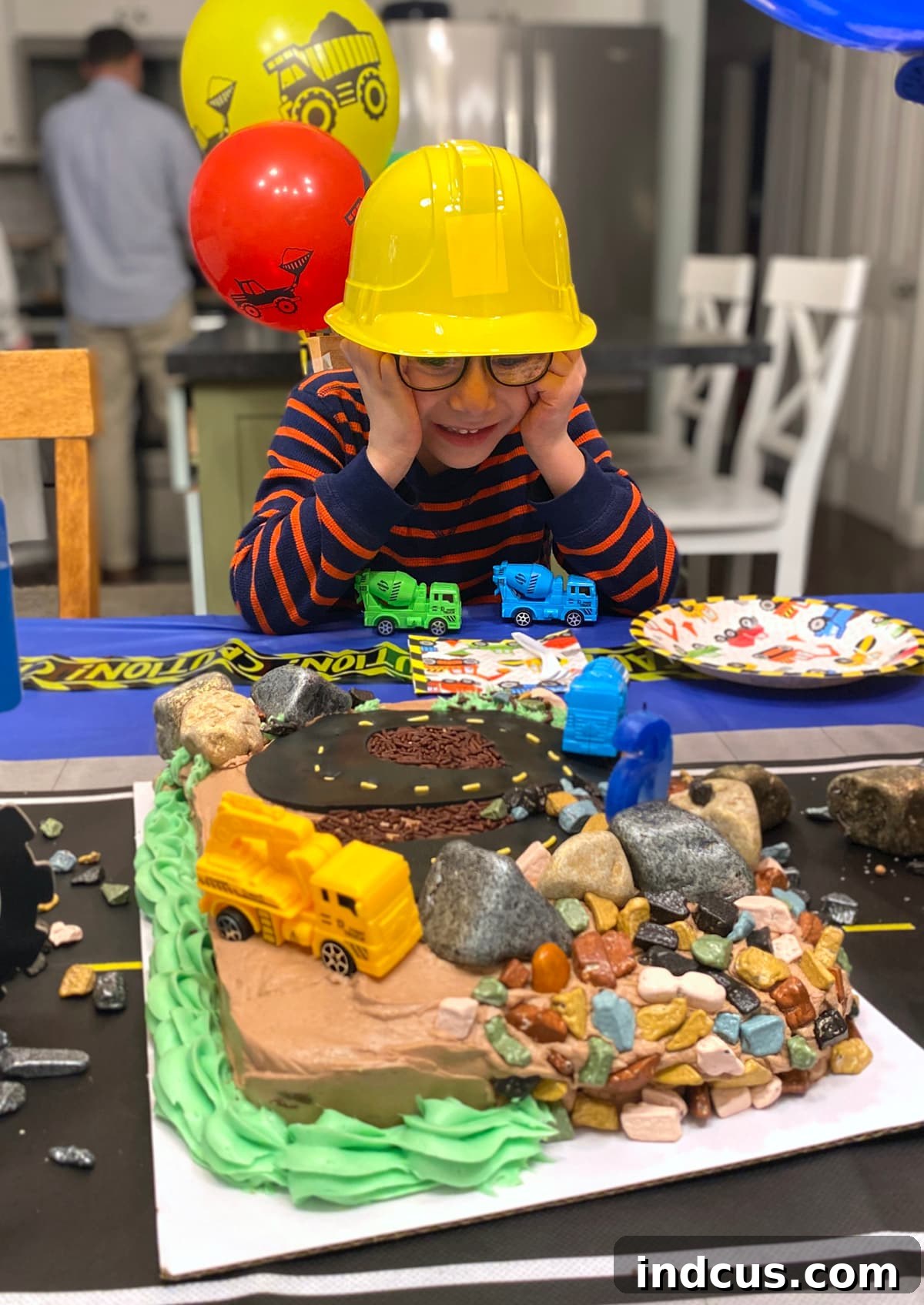 Building a Birthday Bash 7 Six-year-old boy happily looking at his construction themed birthday cake