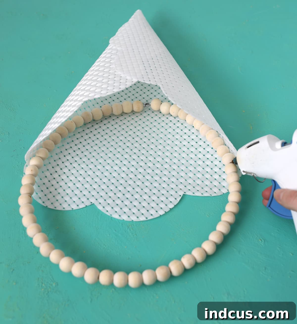 Inserting and gluing a wood bead wreath into a placemat cone
