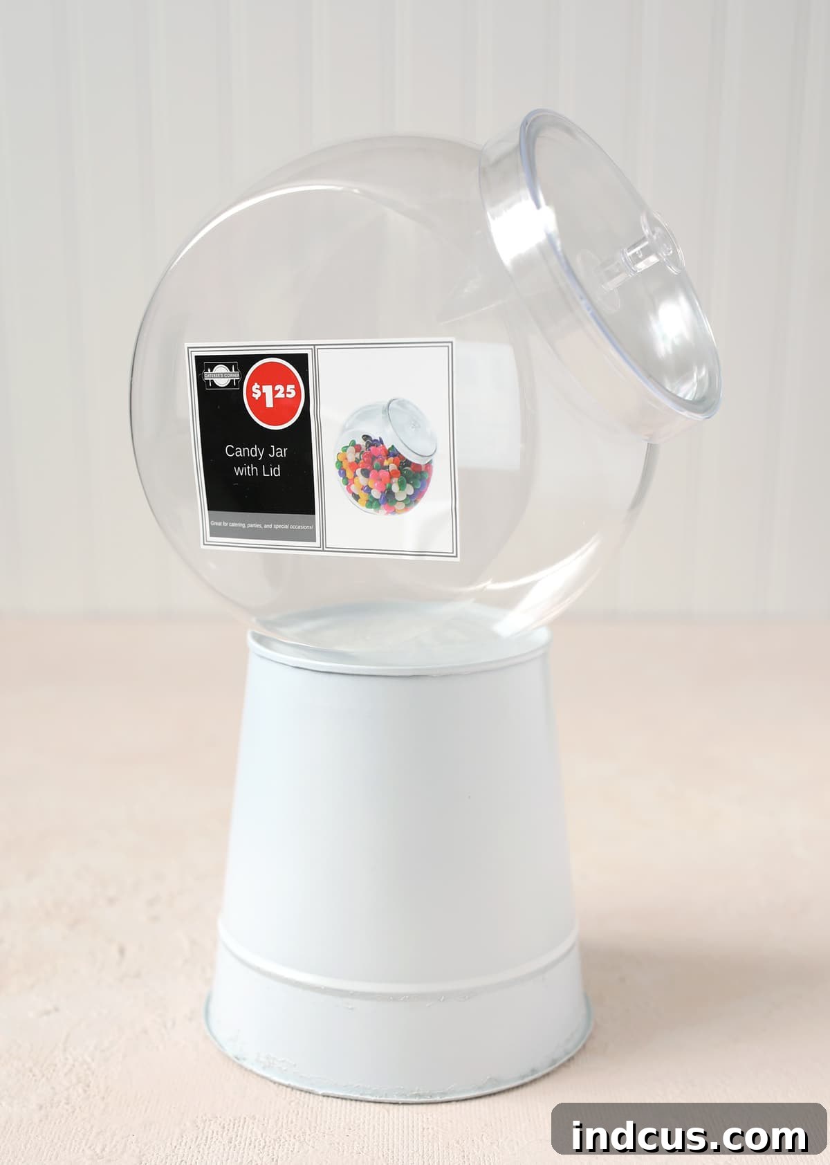 Attaching the clear candy jar securely to the painted metal bucket base with hot glue for stability.