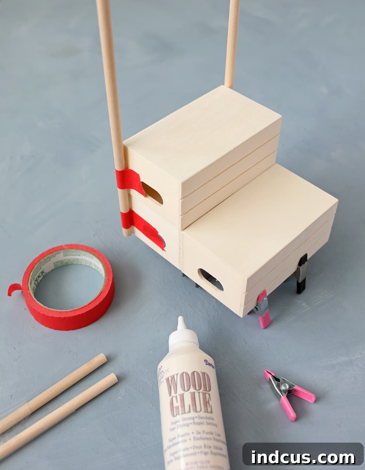 Whip Up Your Easter Candy Haven 4 Assembled wooden crates with dowels attached, forming the structure of the DIY candy stand.