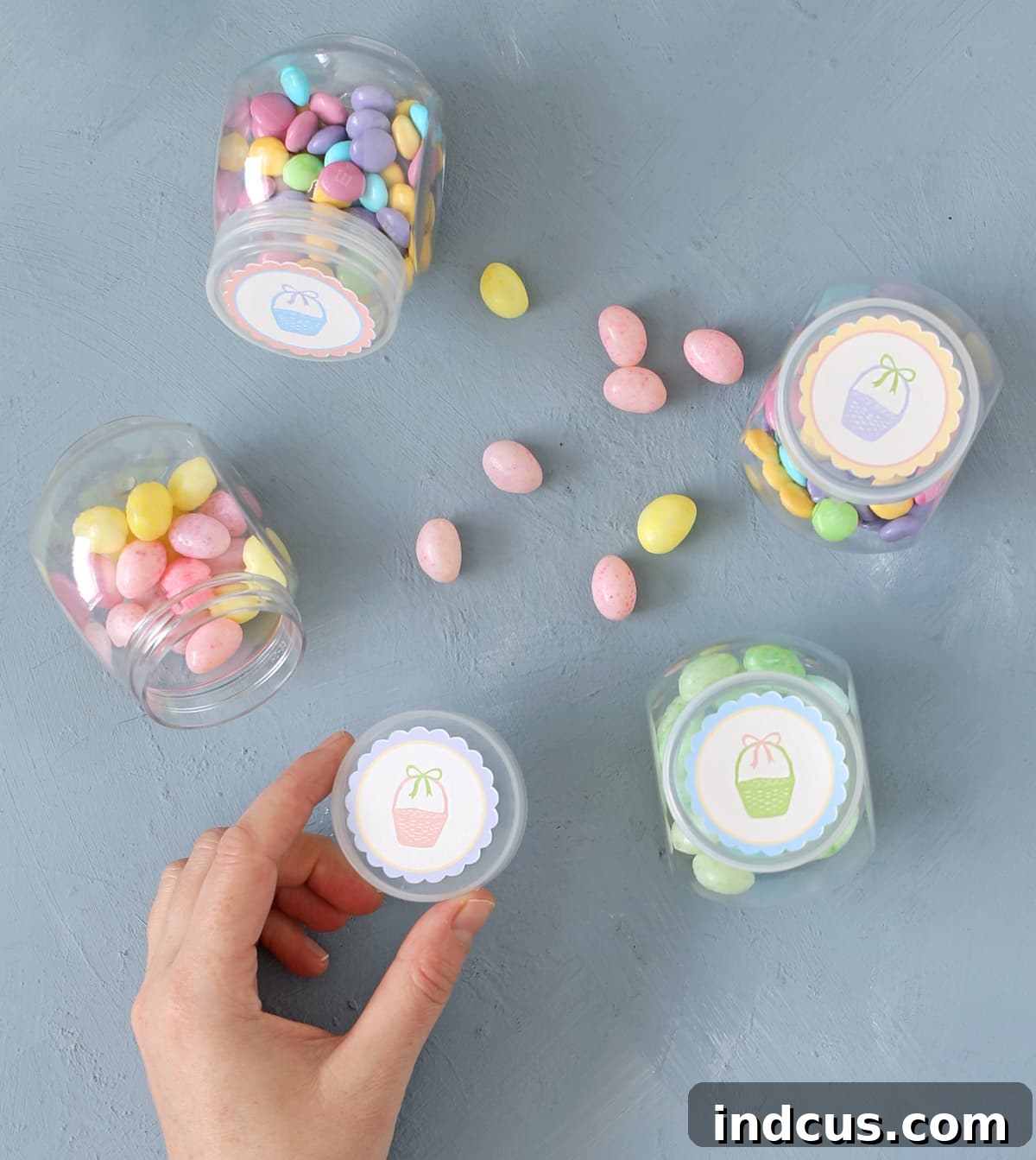Whip Up Your Easter Candy Haven 9 Dollar Tree small candy jars decorated with festive printable Easter lid toppers.