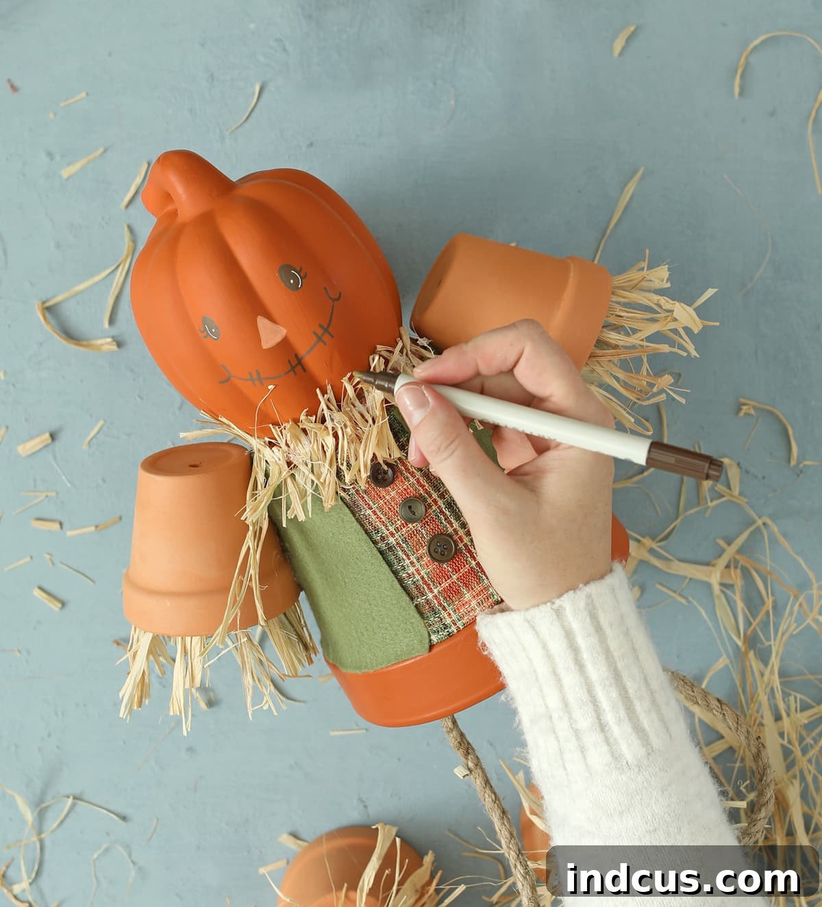 Craft Your Own Clay Pot Scarecrow 8 Drawing a scarecrow face with paint pens on a clay pot