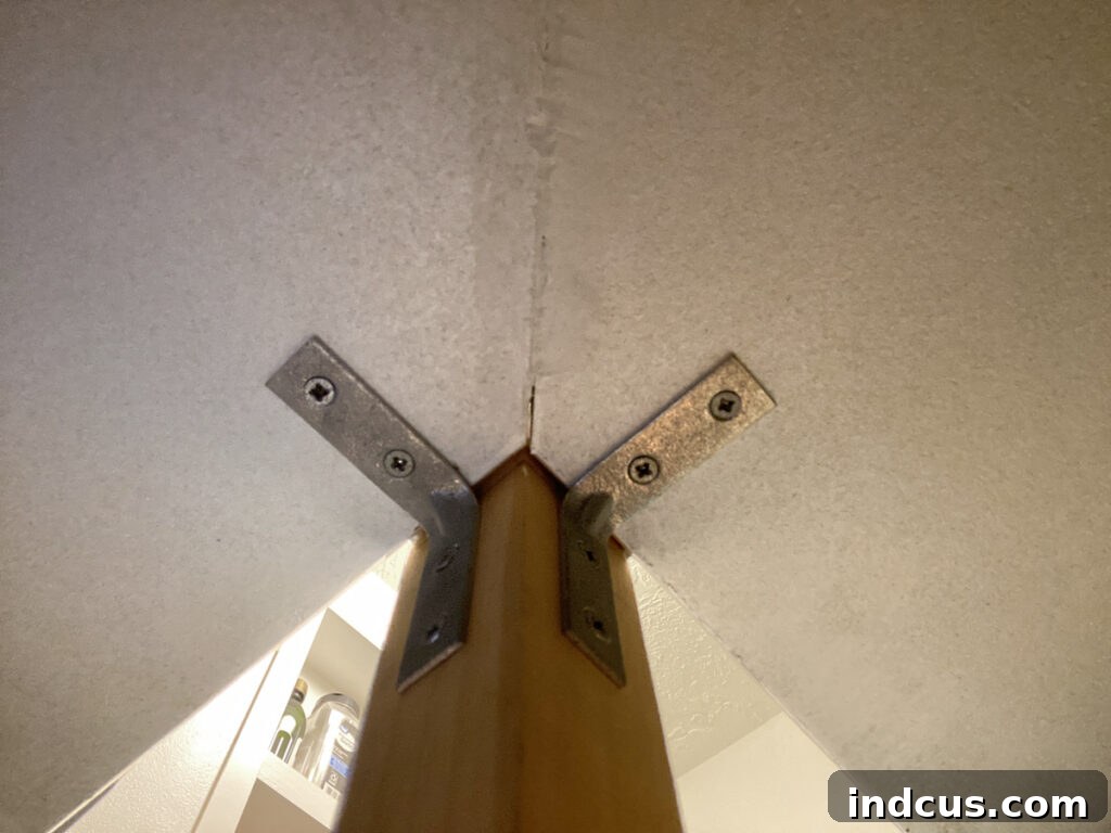 Close-up of L-brackets supporting corner pantry shelves