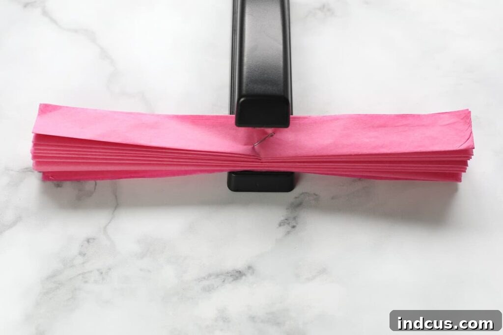 Step 3: Stapling the center of the accordion-folded tissue paper for secure attachment