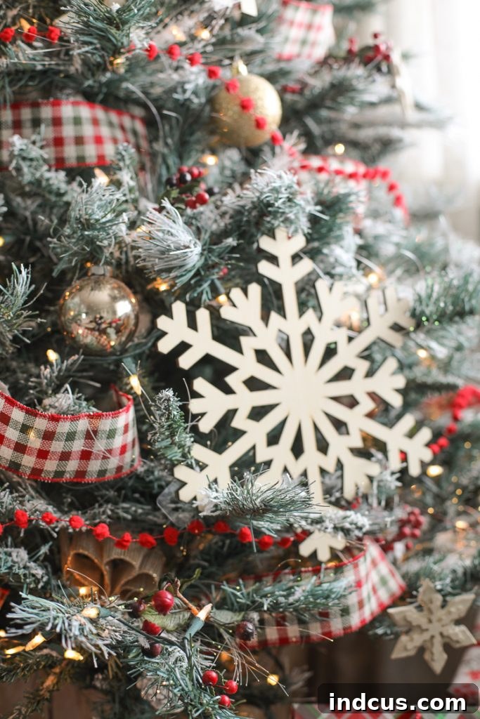 Oversized wooden snowflakes, festive plaid ribbon, and soft pom pom trim adorning a charming farmhouse Christmas tree.