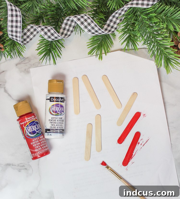 Popsicle sticks painted red and white for Santa ornament