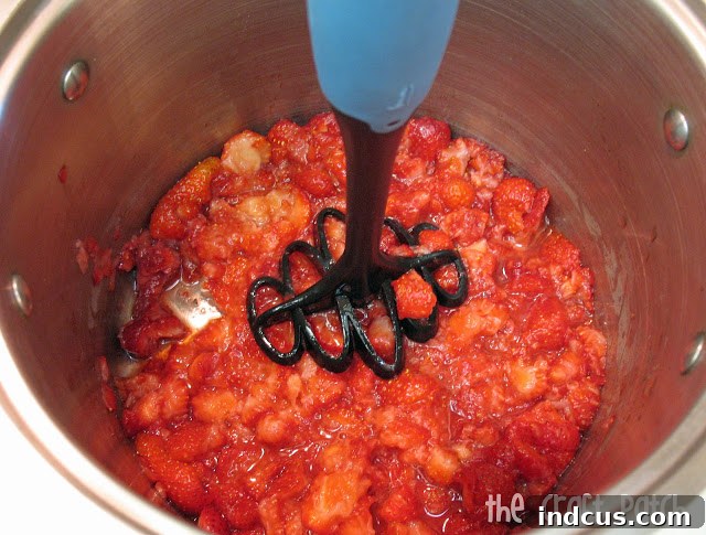 Step by step instructions to making homemade jam - crushing strawberries in a pot
