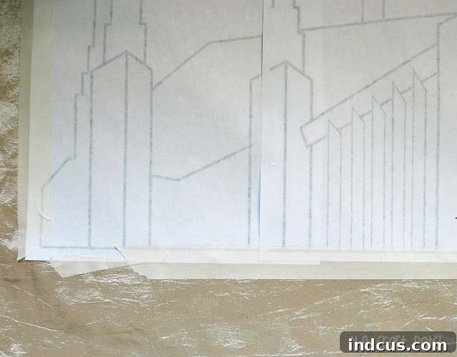 Detailed process of taping a printed building pattern onto the backside of embroidery fabric for tracing and stitching