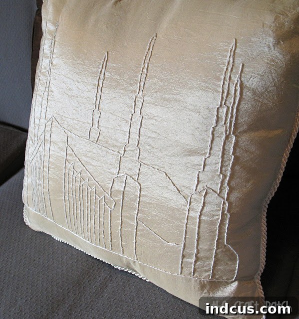 Elegantly finished embroidered pillow featuring an LDS temple, complete with piping, sitting on a sofa as sophisticated home decor