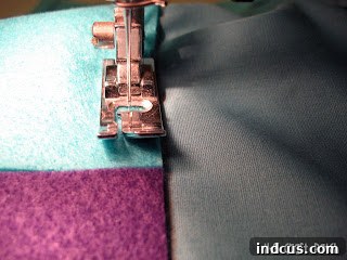 Sew felt pieces to backing fabric along drawn lines