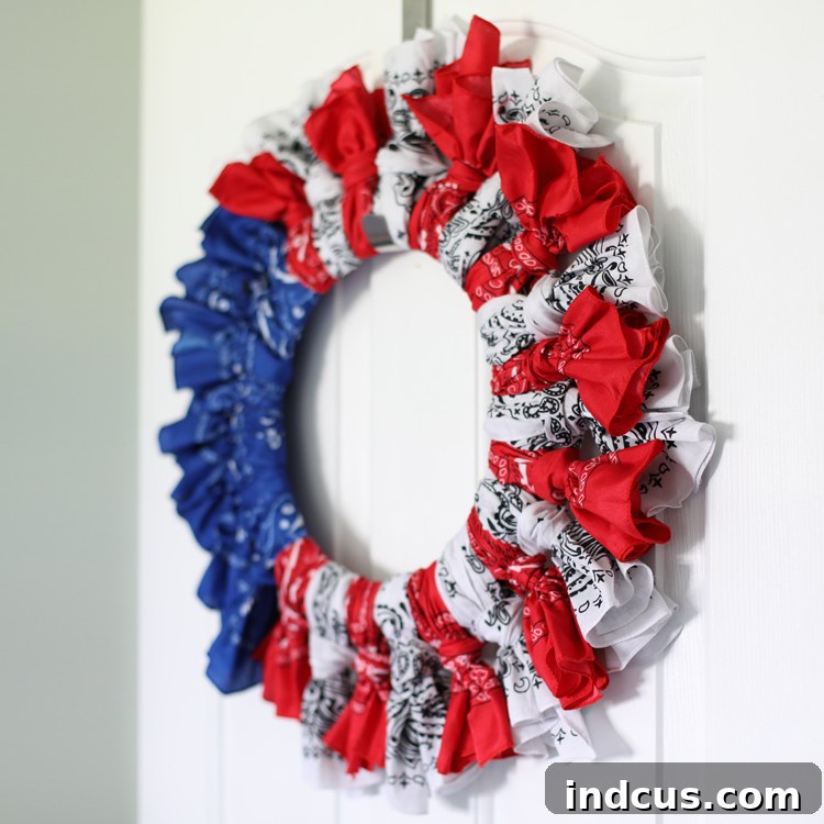 A patriotic bandana wreath in progress, showcasing red, white, and blue bandanas tied onto the wire form.