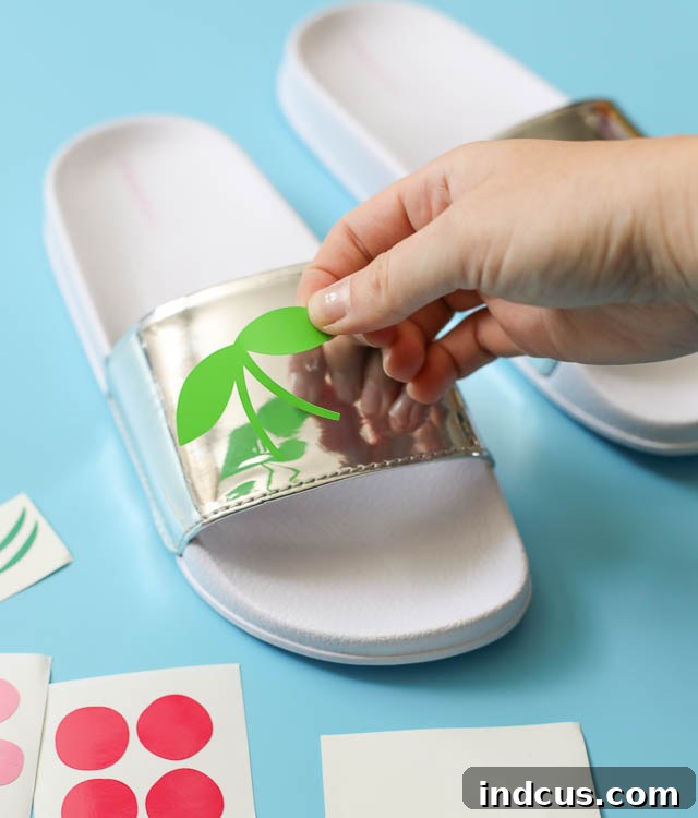 Applying layered cherry vinyl decals to the sandal strap