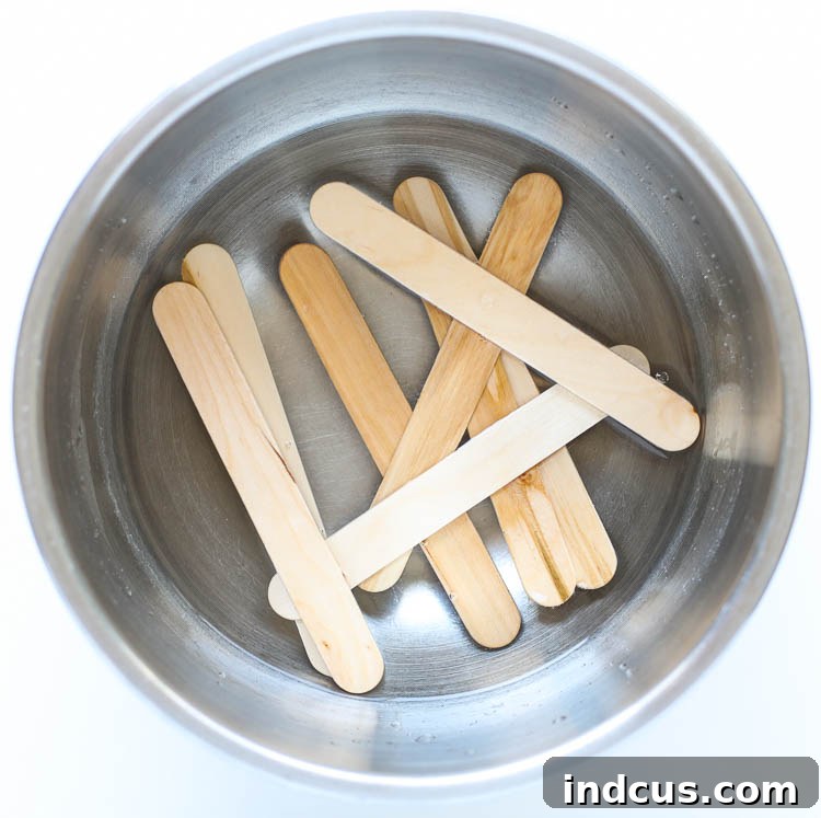 Jumbo popsicle sticks soaking in a glass of hot water to become pliable.