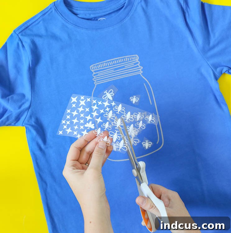 Arranging glow in the dark HTV fireflies on a shirt
