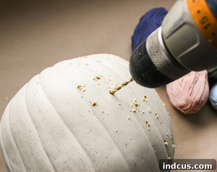 Use a drill to make a cross-stitched design on a foam pumpkin