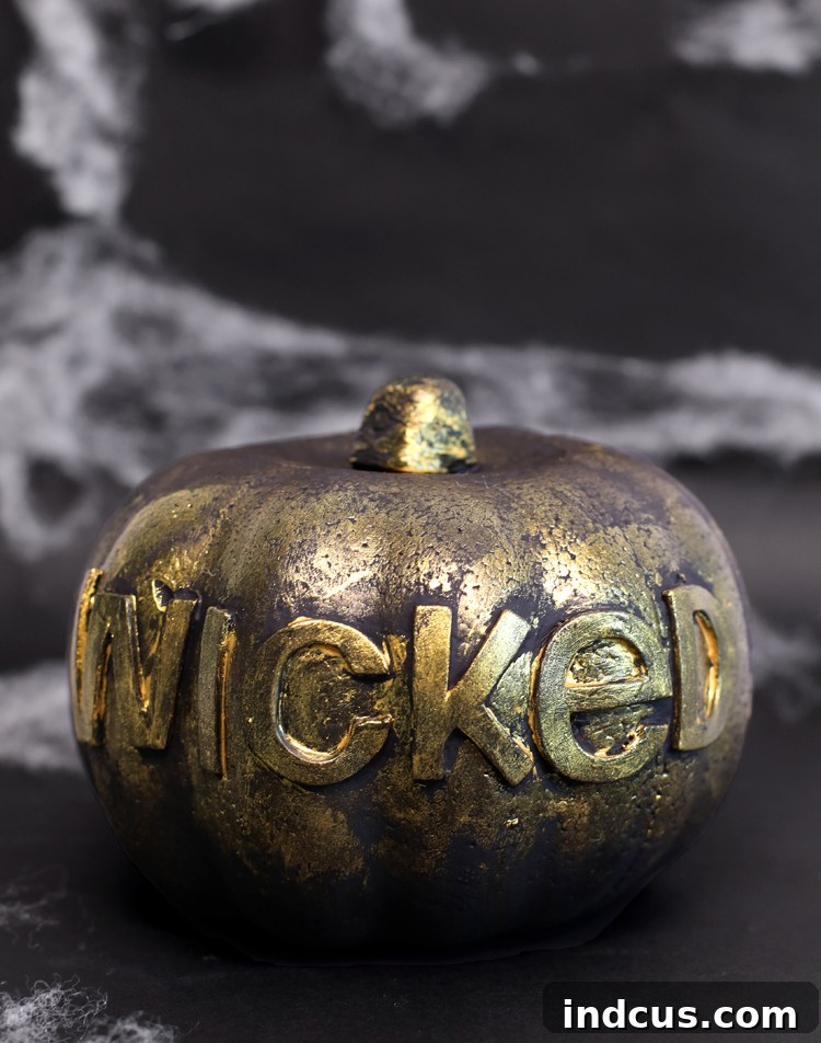 Spooky word painted pumpkin resembling an old spell book