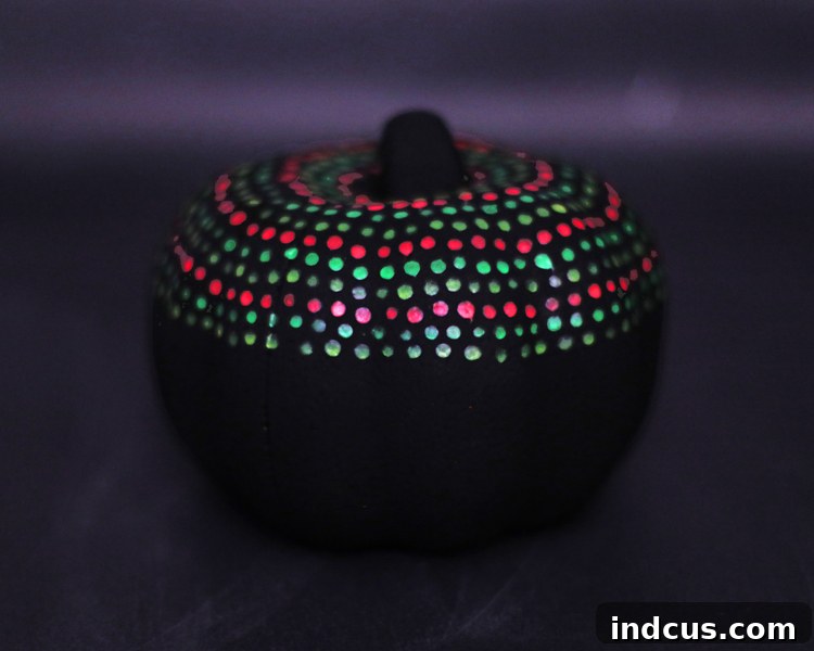 A finished glow-in-the-dark dot painted pumpkin on display.