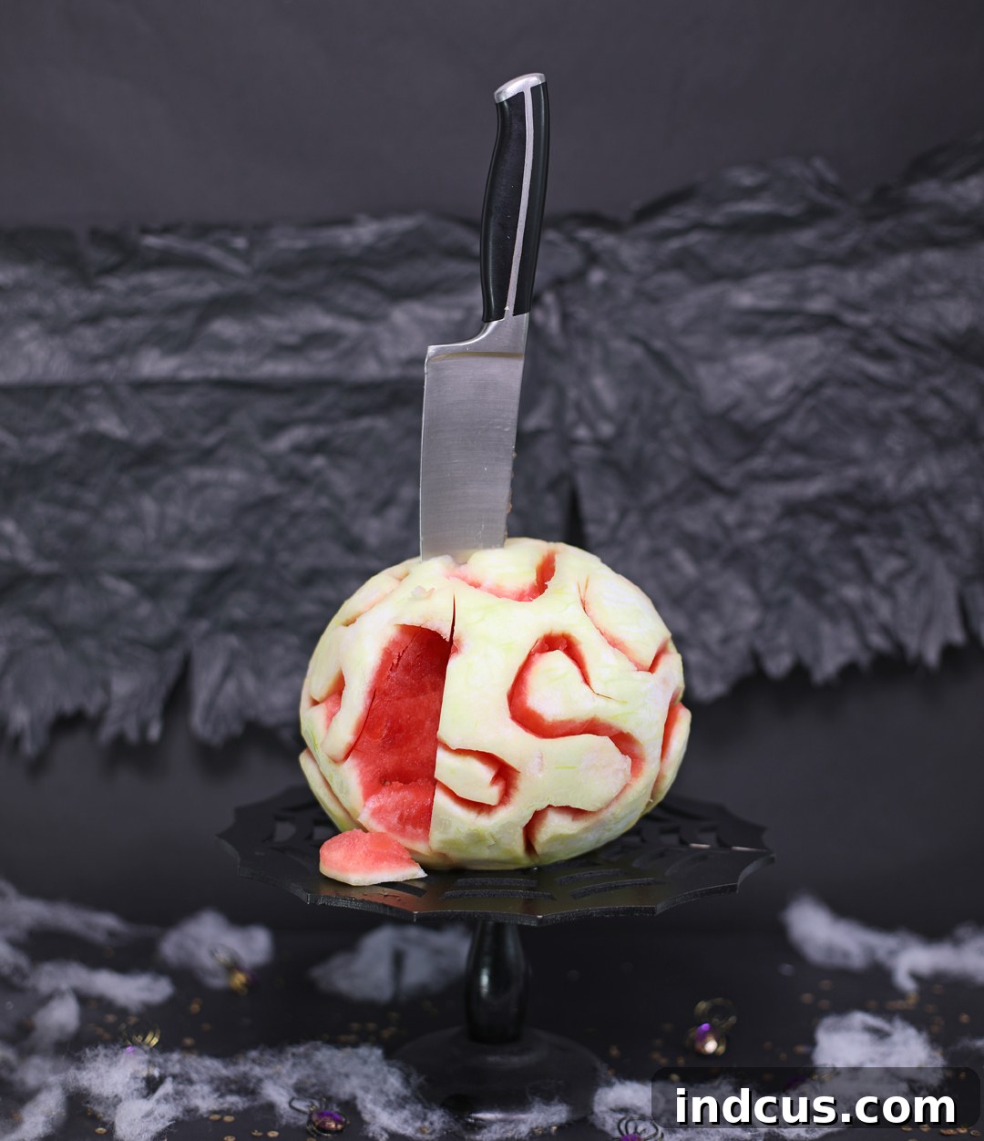 A chillingly realistic edible zombie brain made from watermelon, ready for a Halloween party. It looks incredibly lifelike with its textured surface and red 'blood' glaze.