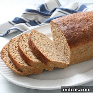 Close-up of a rustic loaf of 100% Whole Wheat Bread with a golden crust.