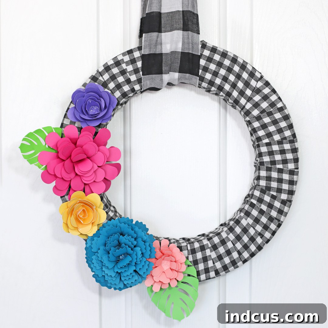 Buffalo check wreath adorned with handmade paper flowers for spring and summer