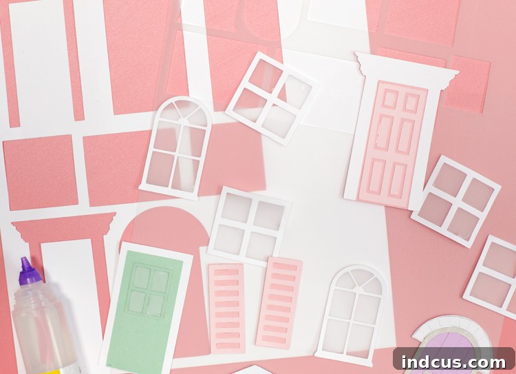 Close-up of two miniature Christmas houses in pastel colors, featuring intricate windows, doors, and miniature decorations like wreaths and a snowman.