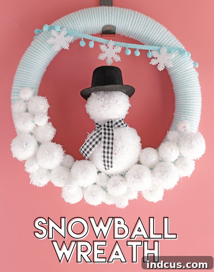 Beautiful handmade winter snowball wreath with yarn, glitter, and a central snowman.