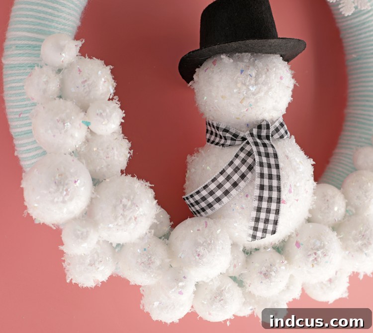 DIY winter wreath idea showing a snowman with a hat and scarf.