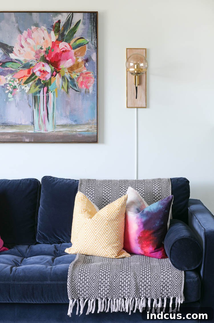 Floral wall art above the sofa flanked by gold wall sconces in a modern living room