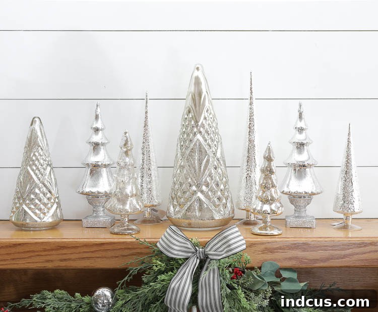 collected mercury glass christmas trees on a mantel