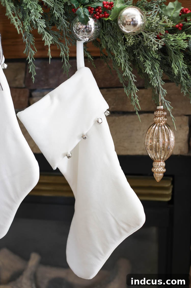 white velvet Christmas stockings on a neutral mantel