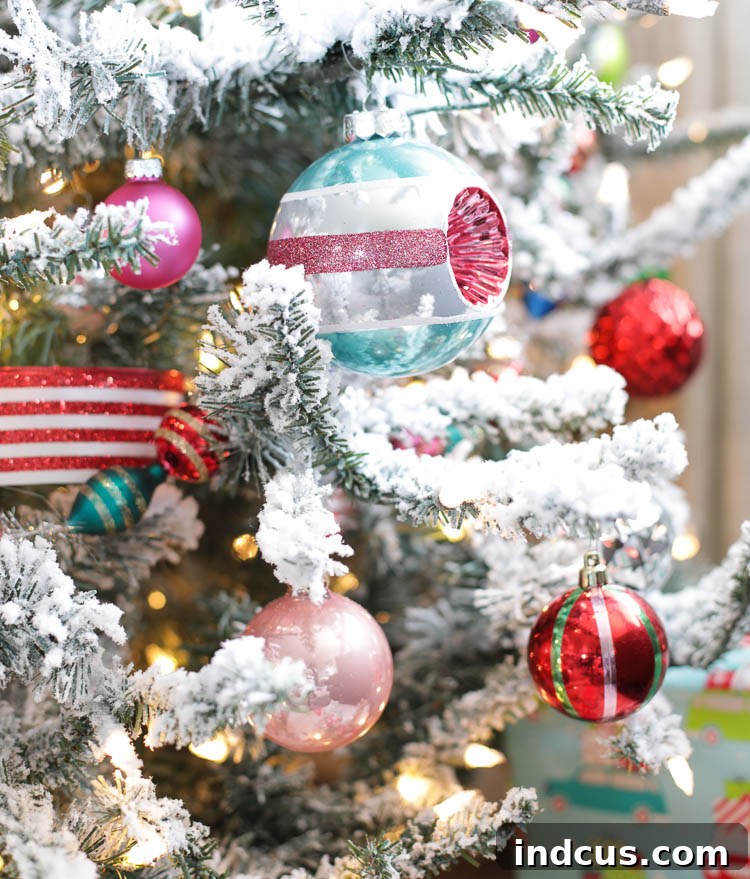 Assortment of colorful Christmas ornaments on a snowy flocked tree