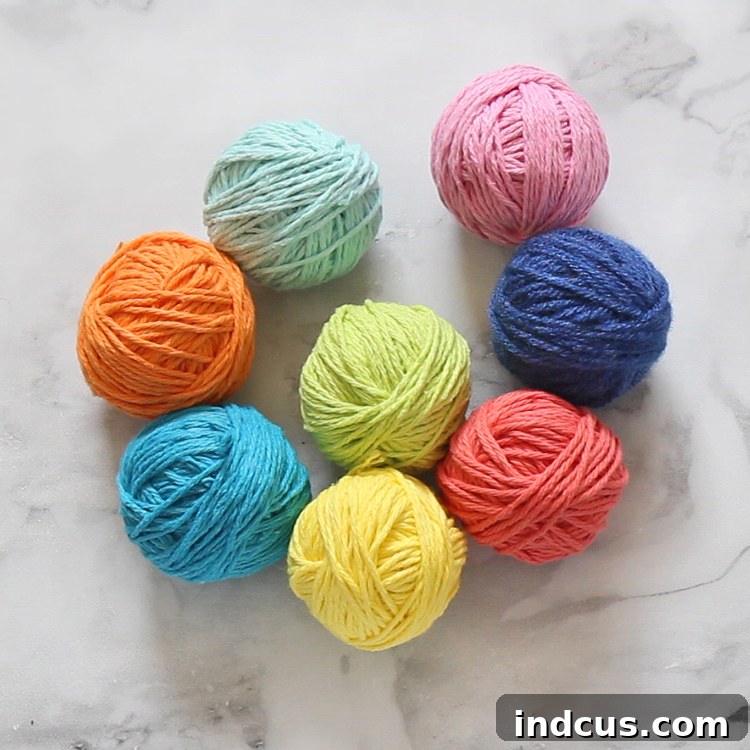 Make a fun rainbow wall hanging out of cotton yarn, perfect for adding vibrant color and a handmade touch to any room.