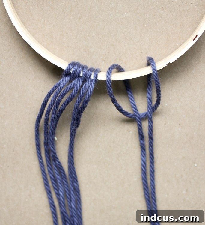 Detailed visual guide on how to tie a lark's head knot for macrame yarn attachment to a hoop