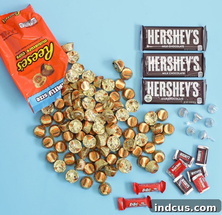 Various candies and a hot glue gun laid out on a table, ready for a DIY candy gift project
