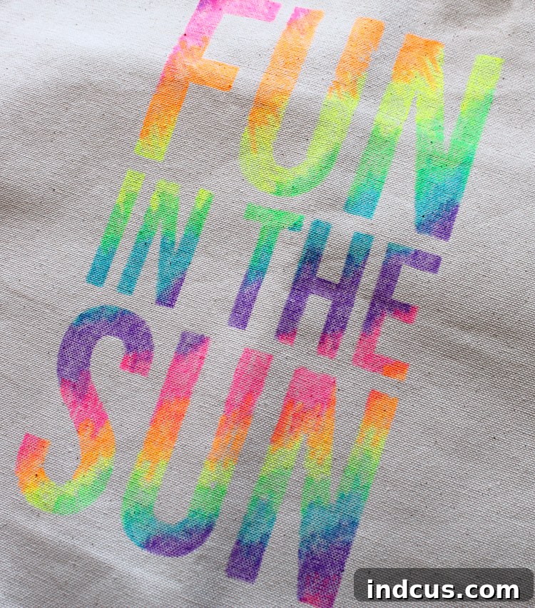 The finished DIY stenciled tote bag, showcasing a 'Sunshine' design with vibrant neon fabric marker colors and a subtle blended effect.