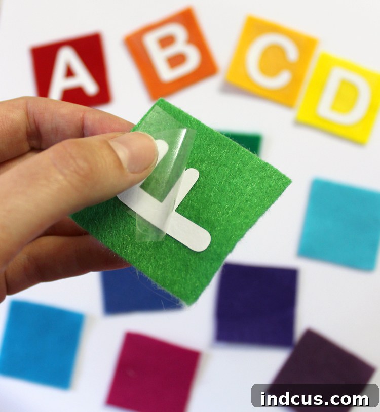 Instructions on how to peel clear paper backing after ironing heat transfer vinyl onto felt