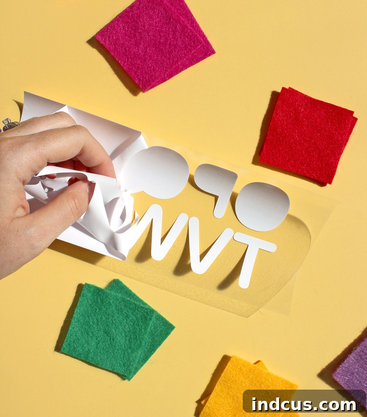 Close-up of how to efficiently weed craft vinyl to prepare letters for heat transfer