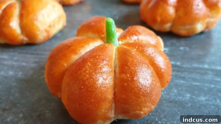 Cute pumpkin-shaped bread rolls with cinnamon sticks for stems.