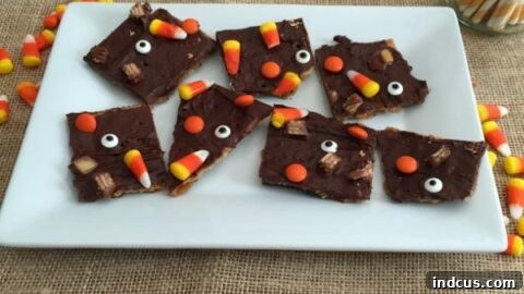 Halloween crack recipe with crackers, toffee, chocolate, candy corn, and candy eyes.