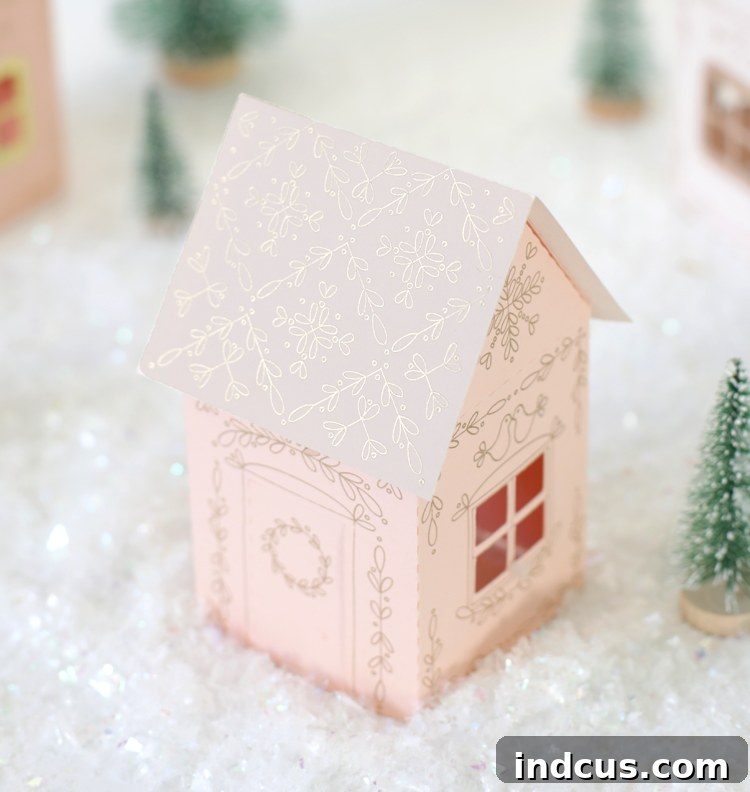 Finished DIY paper Christmas house with free cut file, illuminated by an electric tea light.