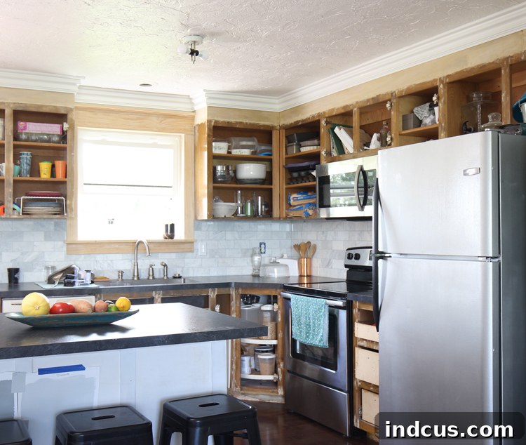 Kitchen cabinets after being extended to the ceiling and finished with foam crown molding, creating a custom look