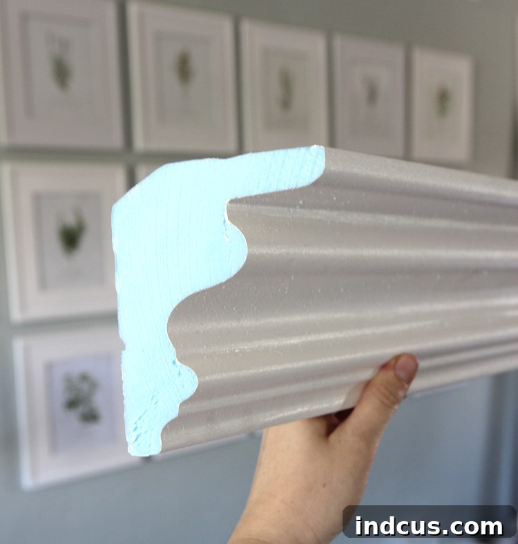 Close-up of painted foam crown molding before installation, showcasing its smooth finish