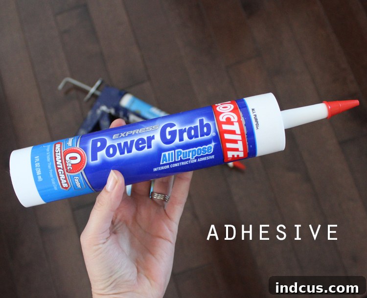 Close-up of LocTite Power Grab All Purpose Adhesive tube, used for foam crown molding installation