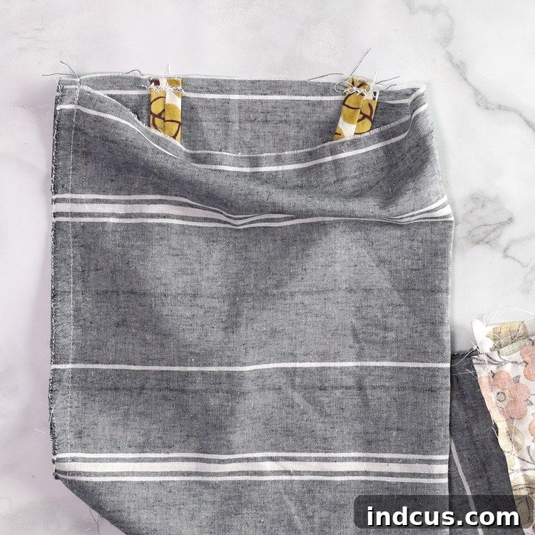 Attaching the strap to the top of the fabric bag dispenser