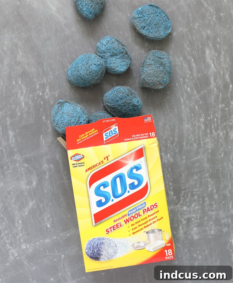A hand holding an SOS pad, ready for cleaning, demonstrating its versatile use.