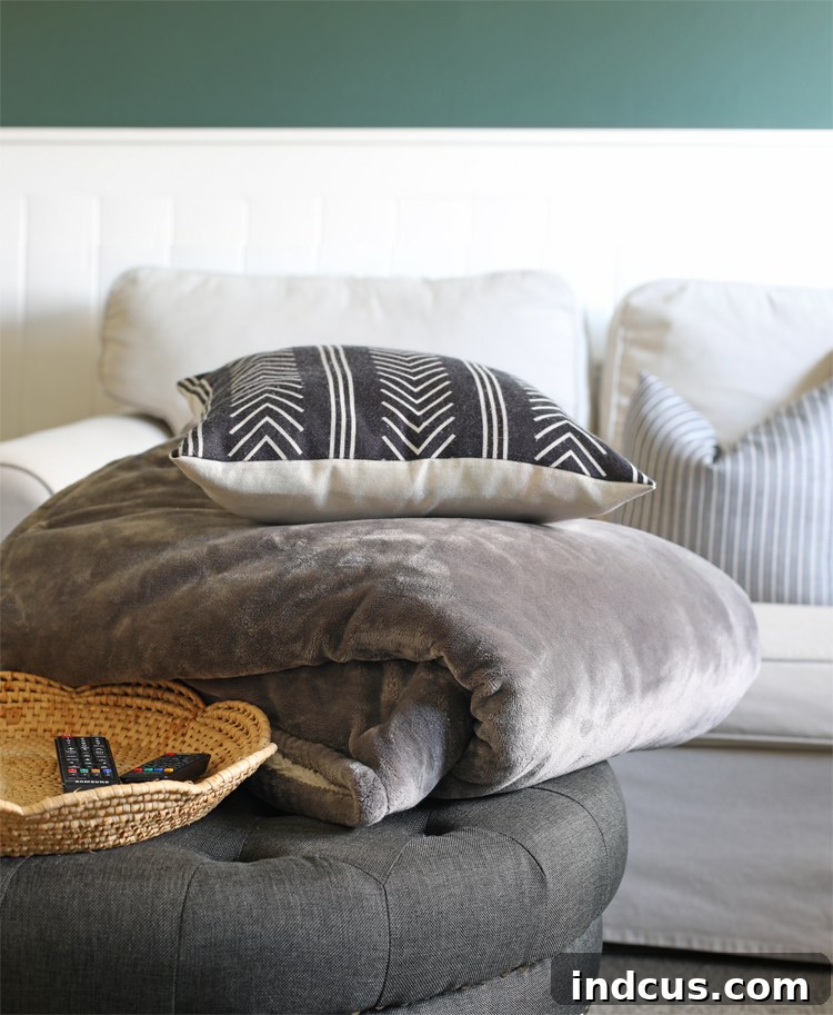 Family members snuggled under blankets in a cozy living room watching TV.