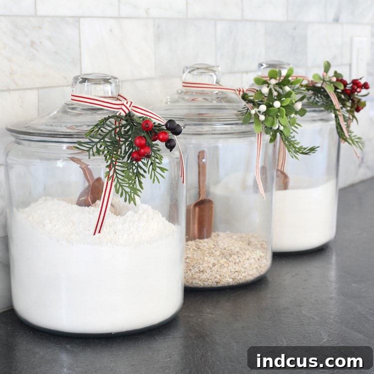 Yuletide Charm: Inside Festive Homes 13 Glass canisters decorated for Christmas with ribbon and greenery, matching the overall home decor.