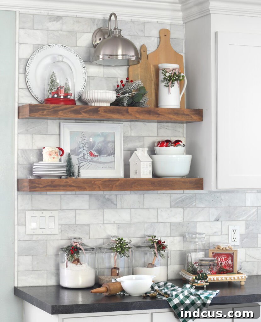 Yuletide Charm: Inside Festive Homes 16 Overall view of a kitchen with open shelves decorated for Christmas, featuring white cabinetry and festive accents.