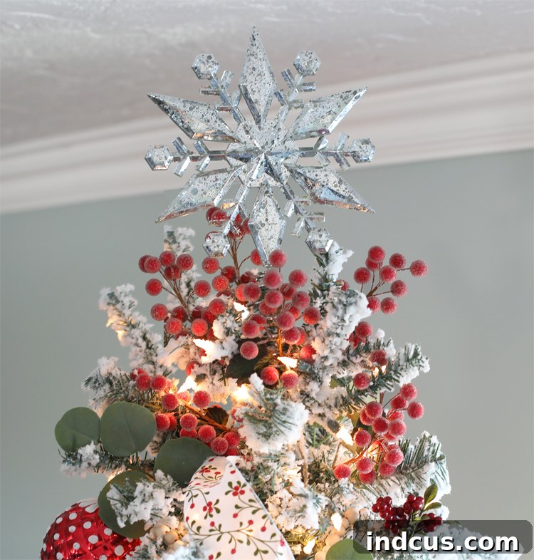 Yuletide Charm: Inside Festive Homes 5 Mercury glass star tree topper on a Christmas tree, sparkling with festive lights.