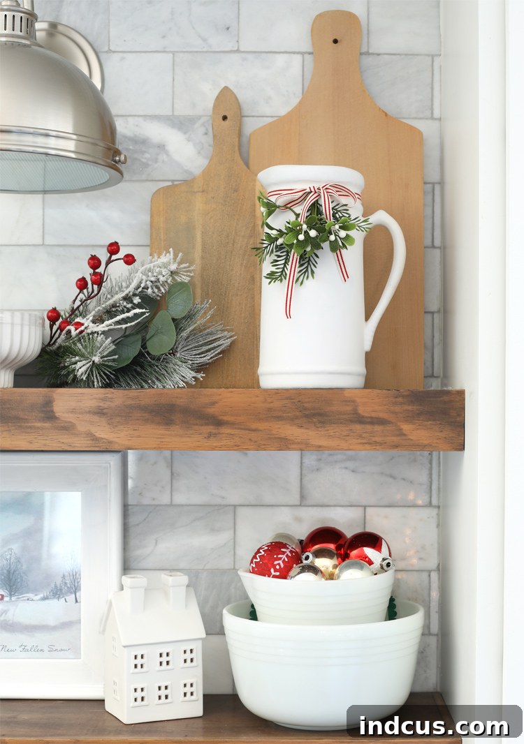 Yuletide Charm: Inside Festive Homes 10 Kitchen counter with simple Christmas decor, including a white ceramic vase with greenery.